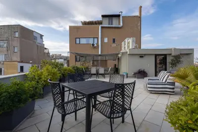 a patio with a table and chairs on a balcony at Entire Building in the Heart of Athens Sleeps 15 with Private Rooftop Terrace in Athens