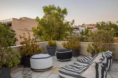 a balcony with four drums and potted trees at Entire Building in the Heart of Athens Sleeps 15 with Private Rooftop Terrace in Athens