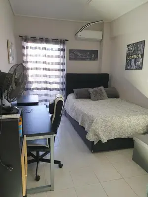 a bedroom with a bed and a desk and a chair at Modern 2BR city flat 10min from the beach in Athens