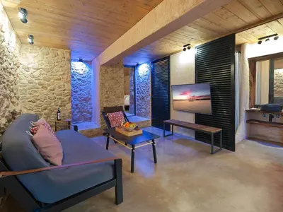 a living room with a couch and a tv at Sea View Garden Suites in Piraeus