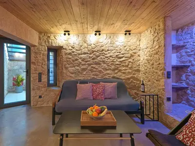 a room with a couch and a table with a bowl of fruit at Sea View Garden Suites in Piraeus