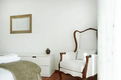 a bedroom with a bed and a chair and a mirror at Luxury Apartment with Exceptional View in Athens