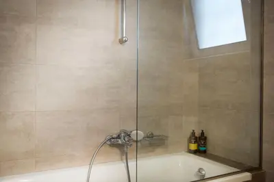 a shower with a glass door and a bath tub at Luxury Apartment with Exceptional View in Athens
