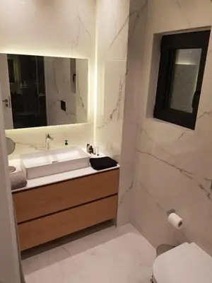 a bathroom with a sink and a mirror and a toilet at Stylish Central Apartment in Kolonaki (walking distance to Syntagma) in Athens