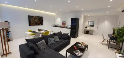 a living room with a black couch and a kitchen at Stylish Central Apartment in Kolonaki (walking distance to Syntagma) in Athens