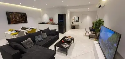 a living room with a couch and a tv and a kitchen at Stylish Central Apartment in Kolonaki (walking distance to Syntagma) in Athens