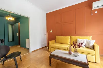a living room with a yellow couch and a table at Spacious High-Ceiling 2-Bedroom by Acropolis Museum in Athens