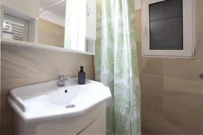 a bathroom with a white sink and a shower curtain at Spacious High-Ceiling 2-Bedroom by Acropolis Museum in Athens