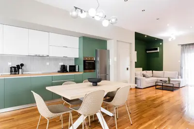a kitchen and living room with a table and chairs at The Gate by Zoia Living in Athens