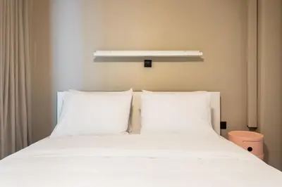 a white bed with white pillows in a room at The Gate by Zoia Living in Athens