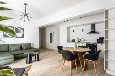 a living room with a green couch and a table and chairs at Kookaki by Zoia Living in Athens