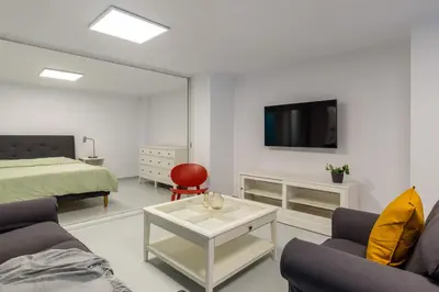 a living room with a bed and a tv on a wall at Kookaki by Zoia Living in Athens
