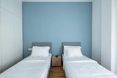 two beds in a room with blue walls at Hi end Pagrati /2bdr apartment ! in Athens