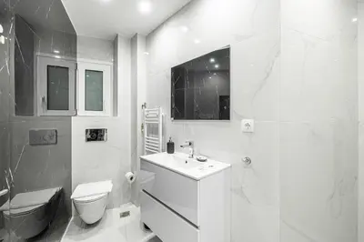 a white bathroom with a toilet and a sink at Hi end Pagrati /2bdr apartment ! in Athens