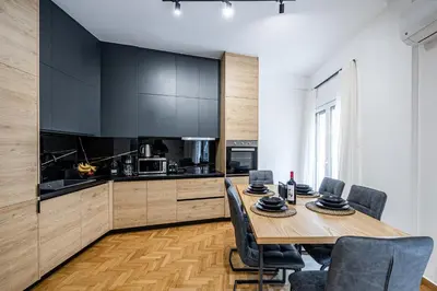 a kitchen with a wooden table and black cabinets at Hi end Pagrati /2bdr apartment ! in Athens