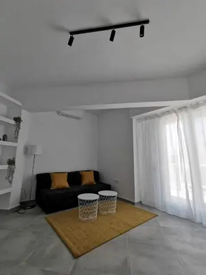 a living room with a couch and a window at Ikarus in Athens
