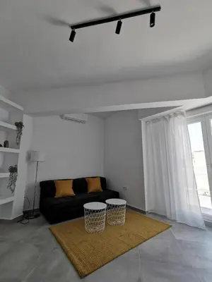 a living room with a black couch and a rug at Ikarus in Athens