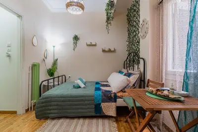 a bedroom with a bed and a table in it at Green boho apartment in Athens