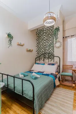 a bedroom with a bed and a wall at Green boho apartment in Athens