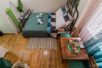 an overhead view of a living room with a bed and a table at Green boho apartment in Athens