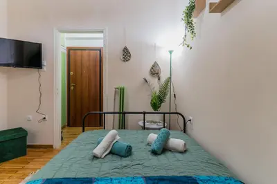 a bedroom with a bed with pillows on it at Green boho apartment in Athens