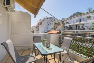 a balcony with a table and chairs on a balcony at lecabetus penthouse in Athens