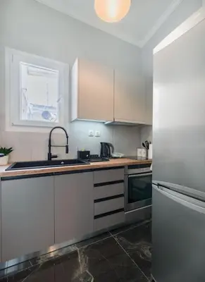a kitchen with white cabinets and a sink and a refrigerator at lecabetus penthouse in Athens
