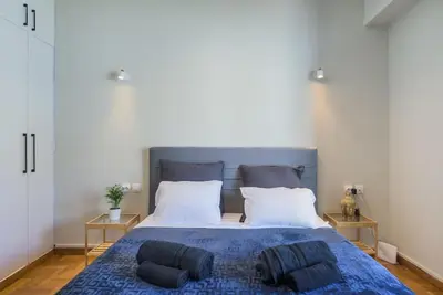 a bedroom with a blue bed with two pillows on it at lecabetus penthouse in Athens
