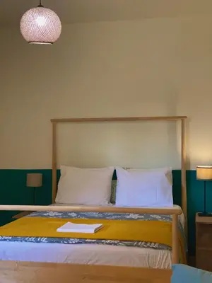 a bedroom with a bed with a wooden headboard at Helen's cozy studio (close to the airport) in Koropíon