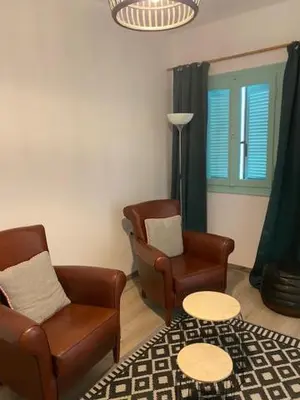 a living room with two chairs and a table at Spata Lykourgos Homes in Spáta