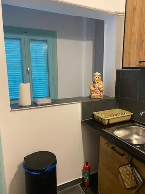 a kitchen with a counter with a sink and a mirror at Spata Lykourgos Homes in Spáta