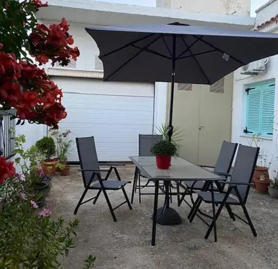 a table and chairs with an umbrella on a patio at Spata Lykourgos Homes in Spáta
