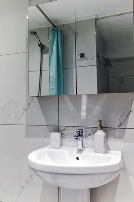 a white bathroom with a sink and a mirror at Dimosthenis_Loft1 in Athens
