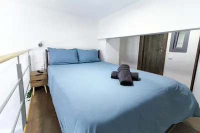 a bedroom with a large bed with blue sheets at Dimosthenis_Loft1 in Athens