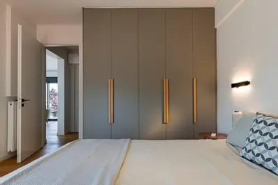 a bedroom with a large bed with gray cabinets at Stylish Contemporary Penthouse - Hip Athens Centre in Athens