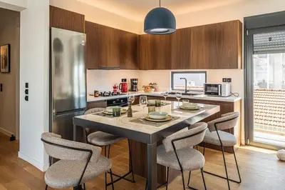 a kitchen with a large island with bar stools at Stylish Contemporary Penthouse - Hip Athens Centre in Athens