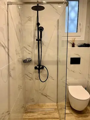 a bathroom with a glass shower with a toilet at Mr Negri in Athens