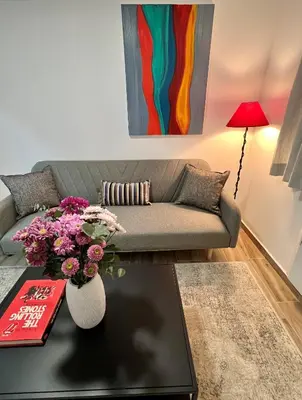 a living room with a couch and a table with flowers at Mr Negri in Athens