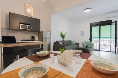 a kitchen and a living room with a table with plates on it at Garden of Eden in Neos Kosmos in Athens