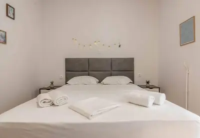 a white bed with two white towels on it at Garden of Eden in Neos Kosmos in Athens