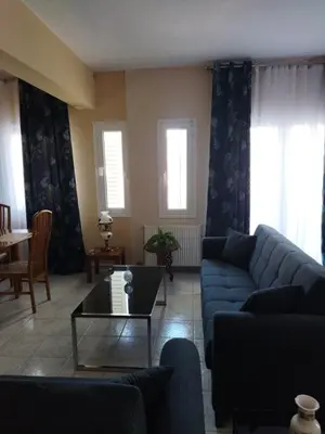 a living room with a blue couch and a table at Airport city center 3 in Spáta