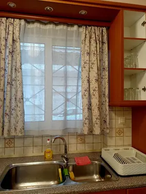 a kitchen sink with a window and a kitchen counter top at Myilios by Ilios Company in Athens