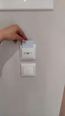 a person holding a white box on a white wall at New Amaryllis Hotel in Athens