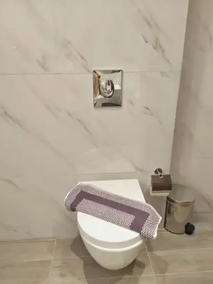 a white toilet in a bathroom with marble walls at New Amaryllis Hotel in Athens