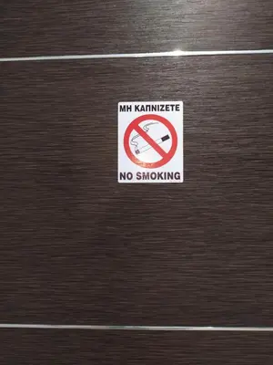a no smoking sign on a wooden door at New Amaryllis Hotel in Athens