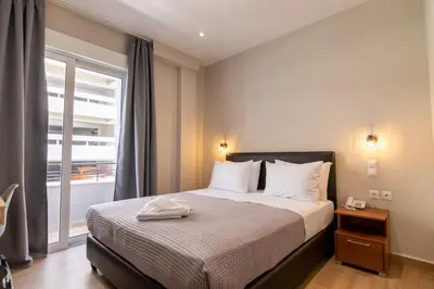 a bedroom with a bed and a large window at New Amaryllis Hotel in Athens
