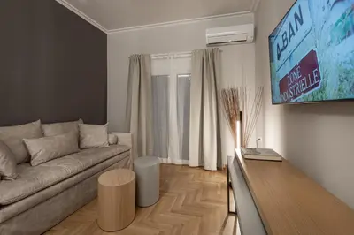 a living room with a couch and a flat screen tv at Like Home Acropolis 50 in Athens