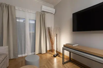 a living room with a flat screen tv on a wall at Like Home Acropolis 50 in Athens