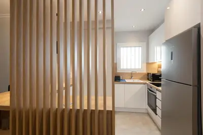 a kitchen with a wooden partition with a refrigerator at Like Home Acropolis 50 in Athens