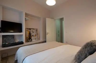 a bedroom with a bed and a flat screen tv at 1BR Athenian Serenity 15 Minutes From Acropolis in Athens